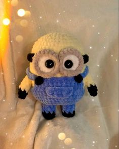 a crocheted minion with big eyes on a white blanket in the snow