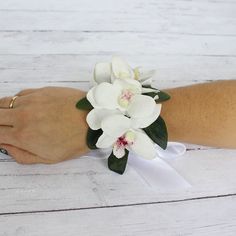 a white wrist corsage with flowers on it