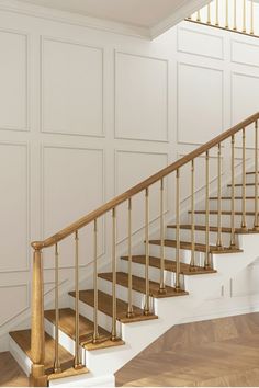 an empty room with white walls and wooden floors has a stair case in the middle