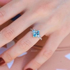 a woman's hand with a ring on it and a blue diamond in the middle