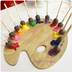 there are many chocolates on the paintbrushes in the shape of an artist's palette