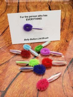 a bunch of hair clips sitting on top of a wooden table next to a card