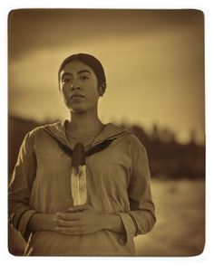 a woman standing in front of a body of water