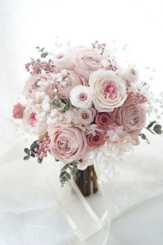 a bridal bouquet with pink roses and baby's breath