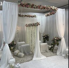 a wedding ceremony with white drapes and flowers on the ceiling, decorated with pink roses