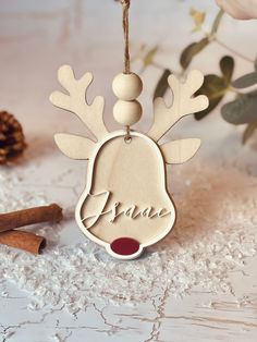 a wooden ornament with the word peace hanging from it's side next to cinnamon sticks