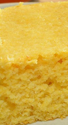 a piece of yellow cake sitting on top of a white plate