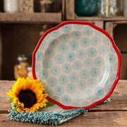 a sunflower sitting on top of a wooden table next to a blue and white plate