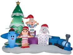 an inflatable christmas scene with three people and a train