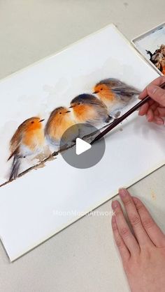 someone is painting three little birds on a piece of paper