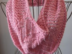 a pink knitted scarf hanging on a chair