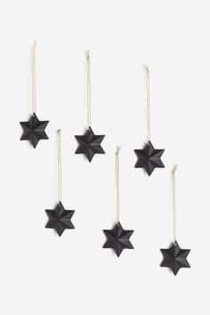 five black stars hanging from strings against a white background