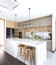 a kitchen with two stools next to an island