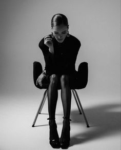 a woman sitting in a chair with her legs crossed