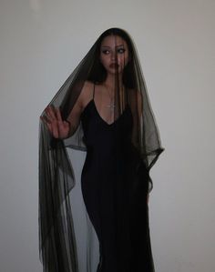 a woman wearing a black dress and veil