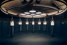 an empty boxing gym with black and white punching bags