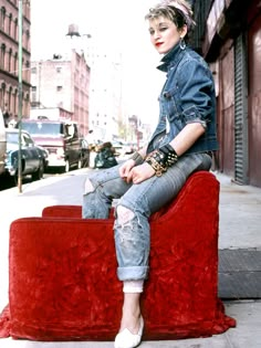 a woman sitting on top of a red bench