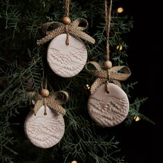 three ceramic ornaments hanging from a christmas tree