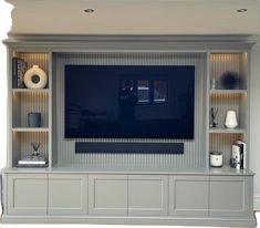 an entertainment center with built - in shelves and a flat screen tv on the wall