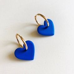 The earrings are made of polymer clay, they are ultra light to the ear. the heart measures 2cm in diameter. All buckles are designed and made by hand in France, they are unique and may vary slightly in color and shape. Polymer clay is a slightly flexible material. The buckle is covered with a light layer of resin so that it is more robust and shiny. The earrings should be stored in a clean, dry place, keep them away from oils, creams and perfumes (do not wear in water). Makeup or other dirt can Trendy Blue Heart Earrings For Gift, Trendy Blue Jewelry With Heart Charm, Handmade Minimalist Blue Hoop Earrings, Blue Handmade Minimalist Hoop Earrings, Minimalist Handmade Blue Hoop Earrings, Trendy Blue Heart-shaped Jewelry, Blue Heart Bead Earrings, Blue Heart-shaped Earrings With Ear Wire, Blue Heart-shaped Earrings With Heart Beads