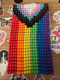 there are many different colored beads in the shape of a rainbow on top of a table