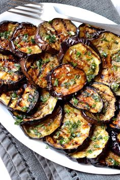 a white plate topped with grilled eggplant