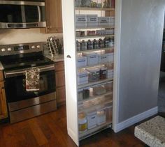 an open pantry door in a kitchen with stainless steel appliances