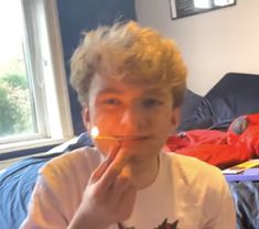 a man with blonde hair is brushing his teeth