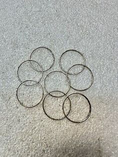 six metal rings sitting on top of a white floor