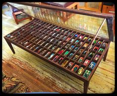 a glass top coffee table with toy figurines on the bottom and underneath it