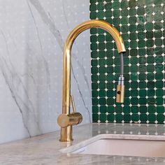 a gold faucet sitting on top of a kitchen counter