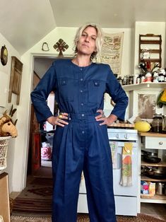 Pretty rad vintage barely worn jumpsuit  Navy blue with a light sheen to the material  Polyester cotton material  Buttons down front one button near the bottom needs a stitch  Elastic back waist  Chest pockets  Side pockets  Pleated pant line at the front hip  Amazing vintage condition  I don't think this was really worn  Tag reads size medium  Fits like a medium/small large  Measurements are approximate and taken flat so please double bust waist and hips for more accurate sizing  Bust: 18.5 in Long Sleeve Denim Jumpsuit With Buttons For Work, Blue Long Sleeve Jumpsuits And Rompers For Fall, Retro Workwear Jumpsuits And Rompers, Retro Style Workwear Overalls And Rompers, Fitted Long Sleeve Overalls With Button Closure, Fitted Vintage Denim Jumpsuit With Long Sleeves, Vintage Fitted Long Sleeve Denim Jumpsuit, Retro Fitted Long Sleeve Jumpsuits And Rompers, Vintage Long Sleeve Jumpsuit For Work