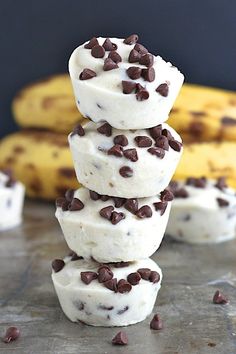 three chocolate chip ice creams stacked on top of each other with bananas in the background