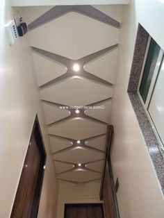 an overhead view of a hallway with wooden floors and white walls, looking down at the ceiling