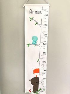 a growth chart wall hanging on the side of a wall with an animal and bird theme