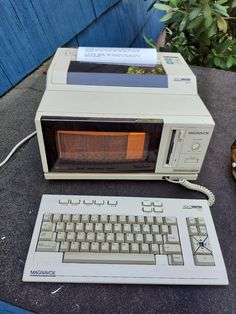 an old computer sitting on top of a table next to a keyboard and mouse,