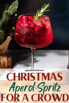 a christmas aperol spritz for a crowd with cranberry and rosemary garnish