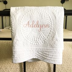 a white towel with the name aldleyynn on it hanging from a black iron bed frame