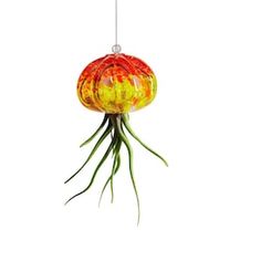 an orange and yellow lamp hanging from a wire on a white background with green stems