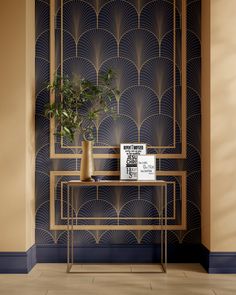 a plant on a table in front of a wall with art deco style pattern and gold accents