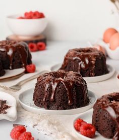 chocolate bundt cake on white plates with raspberries and eggs in the background