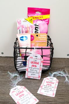 a basket filled with lots of different items on top of a wooden table next to two tags