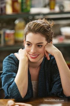 a woman sitting at a table with her hand on her head and looking to the side