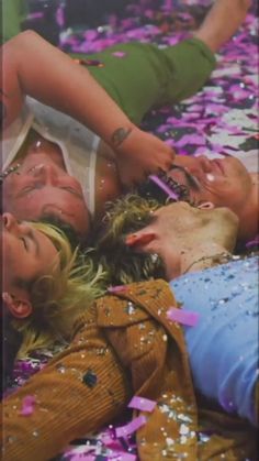 three women laying on the ground surrounded by confetti