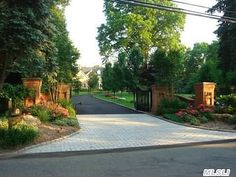 the driveway is lined with trees and flowers