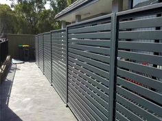 an outdoor area with a fence and trash can