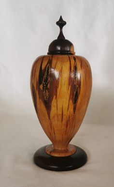 a wooden urn sitting on top of a white table