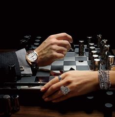 two people playing a game of chess on a checkerboard table with silverware