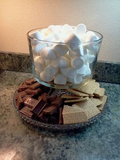 a glass bowl filled with marshmallows on top of a counter