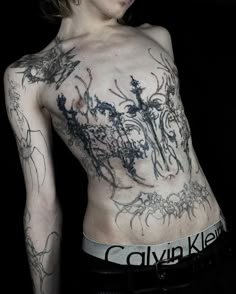 a woman with tattoos on her back and chest is posing for the camera in front of a black background